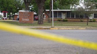 Anggota keluarga berkumpul di luar Ssgt Willie de Leon Civic Center, tempat para siswa dipindahkan dari Sekolah Dasar Robb setelah penembakan, di Uvalde, Texas, AS (24/5/2022).  allison / AFP