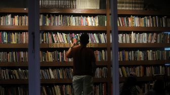 Pengunjung memilih buku untuk dibaca di perpustakaan &quot;Baca Di Tebet&quot;, Jakarta, Rabu (25/5/2022). [Suara.com/Angga Budhiyanto]