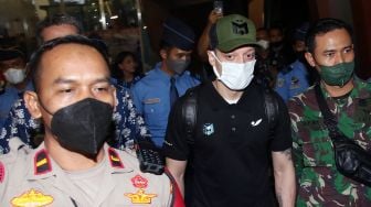 Mantan pesepak bola Timnas Jerman Mesut Ozil (kedua kanan) berjalan keluar setibanya di Bandara Soekarno Hatta, Tangerang, Banten, Selasa (24/5/2020).  ANTARA FOTO/Muhammad Iqbal