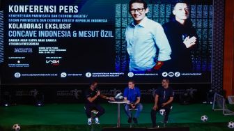 Pesepakbola Mesut Ozil (tengah) bersama Menteri Pariwisata, Ekonomi dan Kreatif (Meparekraf) Sandiaga Uno saat hadir dalam konferensi pers di Kementerian Pariwisata, Ekonomi dan Kreatif (Kemenparekraf), Jakarta Pusat, Rabu (25/5/2022). [Suara.com/Alfian Winanto]