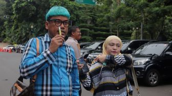 Presenter Uya Kuya didampingi istrinya, Astrid Khairunisha tiba untuk menjalani pemeriksaan di Polda Metro Jaya, Jakarta, Rabu (25/5/2022). [Suara.com/Angga Budhiyanto]