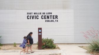 Anggota keluarga berkumpul di luar Ssgt Willie de Leon Civic Center, tempat para siswa dipindahkan dari Sekolah Dasar Robb setelah penembakan, di Uvalde, Texas, AS (24/5/2022).  allison / AFP
