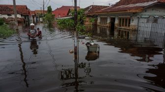 Sejumlah warga berjalan melewati banjir rob di Tirto Gang 12, Pekalongan, Jawa Tengah, Rabu (25/5/2022). ANTARA FOTO/Harviyan Perdana Putra