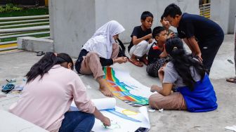 Anak-anak menggambar bersama di Taman Puring, Jakarta Selatan, Kamis (26/5/2022). [Suara.com/Alfian Winanto]