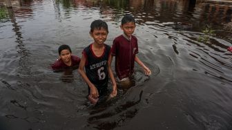 Sejumlah anak berjalan melewati banjir rob di Tirto Gang 12, Pekalongan, Jawa Tengah, Rabu (25/5/2022). ANTARA FOTO/Harviyan Perdana Putra