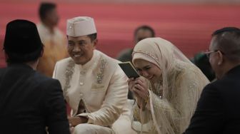 Artis Juliana Moechtar (kedua kanan) didampingi suami Letkol Inf Nur Wahyudi (kedua kiri) menerima buku nikah saat akad nikah di Masjid Istiqlal, Jakarta, Jumat (27/5/2022). [Suara.com/Angga Budhiyanto]