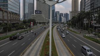 Sejumlah kendaraan melintas di Jalan Jenderal Sudirman Selatan, Jakarta Pusat, Jumat (27/5/2022). [Suara.com/Alfian Winanto]