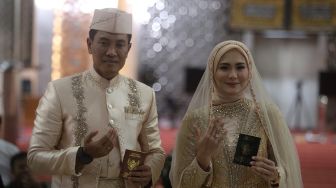 Pasangan Juliana Moechtar dan Letkol Inf Nur Wahyudi menunjukkan cincin dan buku nikah saat akad nikah di Masjid Istiqlal, Jakarta, Jumat (27/5/2022). [Suara.com/Angga Budhiyanto]