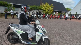 Seorang Aparatur Sipil Negara (ASN) mencoba mengendarai sepeda motor listrik saat peluncuran penyerahan untuk tugas operasional instansi pemerintah di Banda Aceh,Aceh Jumat (27/5/2022).  ANTARA FOTO/Ampelsa
