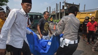 Anggota Polantas dibantu warga mengangkat jenazah korban kecelakaan mobil minibus yang mengalami kecelakaan di Kampung Boru Jalan Syekh Nawawi Kota Serang, Banten, Jumat (27/5/2022). ANTARA FOTO/Asep Fathulrahman
