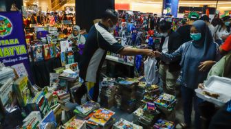 Pengunjung memilih buku komik di acara Jakarta Hobbies Flea Market (JAKFLEA) di Mal Kuningan City, Jakarta Selatan, Sabtu (28/5/2022). [Suara com/Alfian Winanto]