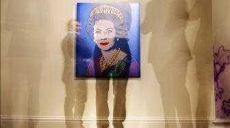 Orang-orang mempelajari &quot;Reigning Queens: Queen Elizabeth II of the United Kingdom&quot; oleh seniman Amerika Andy Warhol saat sesi pemotretan untuk mempromosikan Sotheby&#039;s Jubilee Season, di London, Inggris, Jumat (27/5/2022). [ADRIAN DENNIS / AFP]