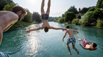 Seorang pemuda melompat ke sungai Aare pada 21 Juni 2017 di Bern, Swiss. [AFP Photo]


