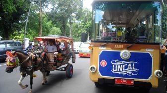 Pengemudi delman melewati bus wisata Uncal di jalan Juanda, Kota Bogor, Jawa Barat, Minggu (29/5/2022). ANTARA FOTO/Arif Firmansyah