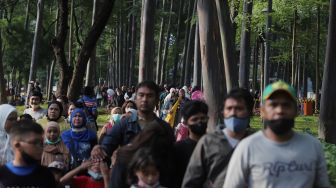 Warga berjalan di Tebet Eco Park, Jakarta, Minggu (29/5/2022). [Suara.com/Angga Budhiyanto]