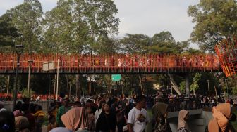 Warga melintasi jembatan Tebet Eco Park di Jakarta, Minggu (29/5/2022). [Suara.com/Angga Budhiyanto]