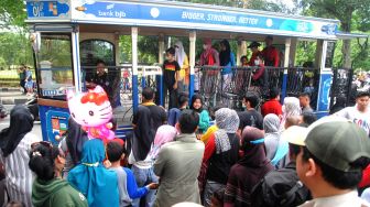Sejumlah warga antre naik bus wisata Uncal di depan Balaikota Bogor, Jawa Barat, Minggu (29/5/2022).  ANTARA FOTO/Arif Firmansyah
