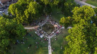 Bunga, mainan, dan sejumlah benda lain diletakkan di tugu peringatan untuk para korban penembakan sekolah yang mengakibatkan kematian 19 anak dan dua guru di Robb Elementary School, Uvalde, Texas, Amerika Serikat, Minggu (29/5/2022). . [AFP/Photo]
