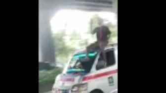 Viral, Aksi Pria Duduk di Atas Ambulans Parpol sambil Pegang Ponsel Ini Buat Netizen Geram