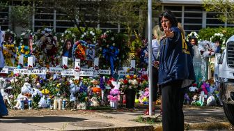 Bunga, mainan, dan sejumlah benda lain diletakkan di tugu peringatan untuk para korban penembakan sekolah yang mengakibatkan kematian 19 anak dan dua guru di Robb Elementary School, Uvalde, Texas, Amerika Serikat, Minggu (29/5/2022). . [AFP/Photo]
