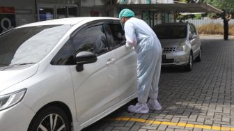 Petugas kesehatan melakukan swab PCR kepada warga di kawasan Cilandak, Jakarta Selatan, Selasa (31/5/2022). [Suara.com/Alfian Winanto]