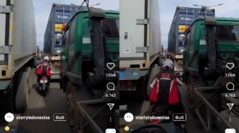 Berkendara di Antara Truk, Aksi Pengendara Motor Ini Bikin Merinding