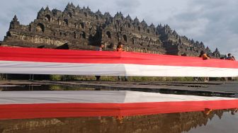 Peserta membentangkan bendera merah putih mengelilingi Candi Borobudur saat peringatan Hari Lahir Pancasila di Taman Wisata Candi (TWC) Borobudur, Magelang, Jawa Tengah, Rabu (1/6/2022). ANTARA FOTO/Anis Efizudin