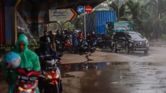 Sejumlah pengendara sepeda motor berteduh dibawah kolong fly over saat hujan di Tanjung Priok, Jakarta Utara, Kamis (2/6/2022). [Suara.com/Alfian Winanto]