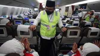 Menteri Agama Yaqut Cholil Qoumas menyapa jamaah calon haji yang akan berangkat ke Tanah Suci saat berada dalam pesawat di Terminal 2F Bandara Soekarno Hatta, Tangerang, Banten, Sabtu (4/6/2022). [ANTARA FOTO/Muhammad Iqbal/nym]
