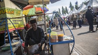 Pedagang kerak telor memasak untuk pembelinya dalam Lebaran Tenabang 2022 di depan Kantor Kecamatan Tanah Abang, Jakarta, Sabtu (4/6/2022).ANTARA FOTO/Aprillio Akbar
