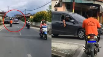 Kocak! Pria Pakai Baju Tahanan Kendarai Sepeda Motor di Depan Mobil Polisi