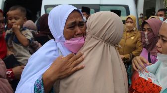 Seorang calon haji memeluk anggota keluarganya saat pelepasan keberangkatan di halaman Pemkab Jombang, Jawa Timur, Senin (6/6/2022). ANTARA FOTO/Syaiful Arif
