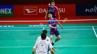 Pebulu tangkis ganda putra Indonesia Marcus Gideon dan Kevin Sanjaya melakukan serangan kepada pebulu tangkis ganda putra Prancis Christo Popov dan Toma Junior Popov pada babak kualifikasi Daihatsu Indonesia Master 2022 di Istora Senayan,  Jakarta Pusat, Selasa (7/6/2022). [Suara.com/Alfian Winanto]