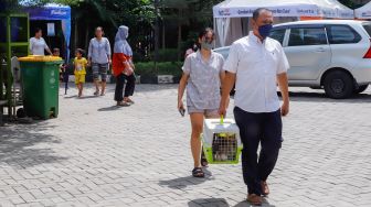 Warga membawa hewan peliharaannya untuk divaksin rabies di Kantor Kecamatan Duren Sawit, Jakarta Timur, Selasa (7/6/2022). [Suara.com/Alfian Winanto]