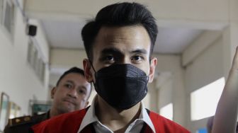 Terdakwa kasus pelanggaran Undang-Undang (UU) ITE Adam Deni berjalan menuju ruang sidang di Pengadilan Negeri Jakarta Pusat, Selasa (7/6/2022). [Suara.com/Angga Budhiyanto]