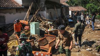 Anggota TNI dan relawan membantu menyelematkan berbagai barang milik warga pascabanjir bandang di Kampung Kaum Kidul, Ciwidey, Kabupaten Bandung, Jawa Barat, Selasa (7/6/2022). ANTARA FOTO/Raisan Al Farisi