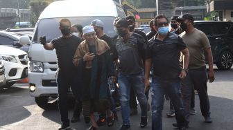 Sejumlah polisi mengamankan kedatangan petinggi organisasi Khilafatul Muslimin, Abdul Qadir Baraja (ketiga kiri) saat tiba di Polda Metro Jaya, Jakarta, Selasa (7/6/2022). [ANTARA FOTO/Aditya Pradana Putra/foc]
