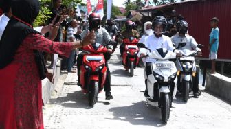 Dibonceng Jokowi, Begini Gaya Iriana Saat Naik Motor Listrik di Kampung Mola