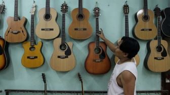 Pekerja menata gitar di sentra produksi dan reparasi gitar Pak Manto di Jalan Langgar II, Pejaten Timur, Pasar Minggu, Jakarta, Kamis (9/6/2022). [Suara.com/Angga Budhiyanto]