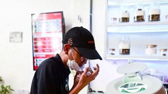 Pelanggan mencium ganja di dalam Highland Cafe pada hari pertama penghapusan ganja dari daftar narkotika berdasarkan hukum Thailand di Bangkok, Thailand, (9/6/2022). Manan VATSYAYANA / AFP

