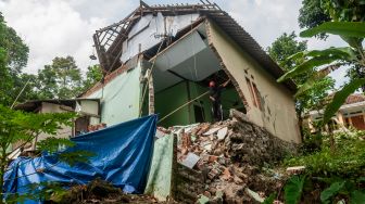 Warga melihat kondisi rumah yang rusak akibat pergerakan tanah di Desa Cilangkap, Lebak, Banten, Sabtu (11/6/2022). [ANTARA FOTO/Muhammad Bagus Khoirunas/foc]