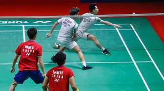 Pebulu tangkis ganda putra Indonesia Marcus Gideon dan Kevin Sanjaya melakukan serangan kepada pebulu tangkis ganda putra Cina Liang Wei Keng dan Wang Chang pada babak semi final Daihatsu Indonesia Master 2022 di Istora Senayan,  Jakarta Pusat, Sabtu (11/6/2022). [Suara.com/Alfian Winanto]