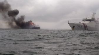 Petugas menggunakan KN Pulau Dana-323 melakukan pemadaman api saat terjadi kebakaran KM Bintang Surya di Perairan Karimun, Selat Malaka, Riau, Minggu (12/6/2022).