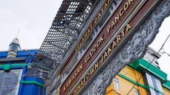 Pekerja menyelesaikan pembangunan konstruksi proyek gapura Chinatown di Glodok, Jakarta Barat, Selasa (14/6/2022). [Suara.com/Alfian Winanto]