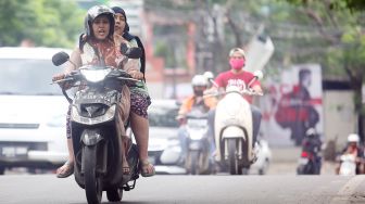Sejumlah pengendara motor memakai sandal jepit melintas di Jalan Raya Ciledug, Kreo, Tangerang, Banten, Selasa (14/6/2022).  ANTARA FOTO/Muhammad Iqbal