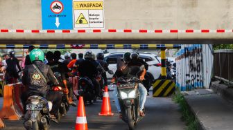 Pengendara motor melintas di Jembatan Antelope, Curug, Bekasi, Jawa Barat, Selasa (14/6/2022). [Suara.com/Alfian Winanto]