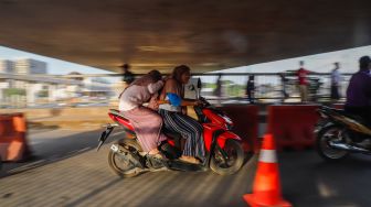 Pengendara motor melintas di Jembatan Antelope, Curug, Bekasi, Jawa Barat, Selasa (14/6/2022). [Suara.com/Alfian Winanto]