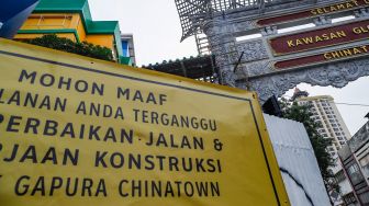 Pekerja menyelesaikan pembangunan konstruksi proyek gapura Chinatown di Glodok, Jakarta Barat, Selasa (14/6/2022). [Suara.com/Alfian Winanto]