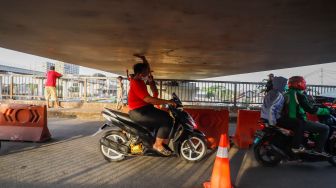 Pengendara motor melintas di Jembatan Antelope, Curug, Bekasi, Jawa Barat, Selasa (14/6/2022). [Suara.com/Alfian Winanto]