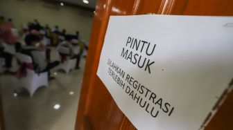 Petugas melayani warga yang berkonsultasi terkait pendaftaran daring Penerimaan Peserta Didik Baru (PPDB) 2022 di Posko Pelayanan PPDB SMA Negeri 70 Jakarta Selatan, Jakarta, Selasa (14/6/2022). [Suara.com/Alfian Winanto]